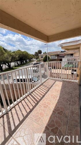 A balcony with a metal railing and a tiled floor.