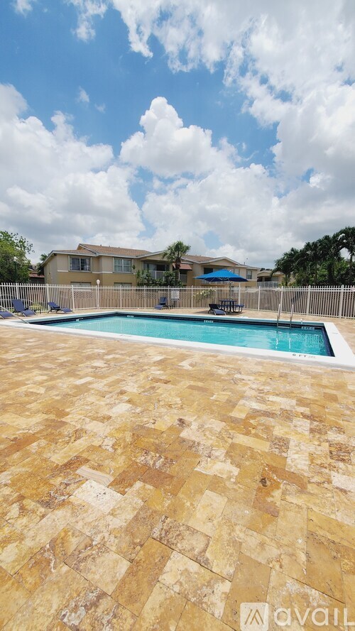 A pool surrounded by a tiled patio.