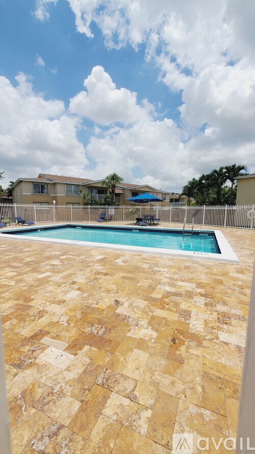 A pool surrounded by a tiled patio.