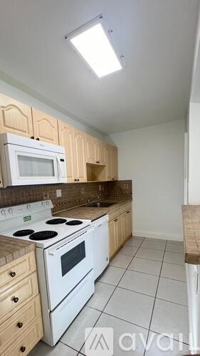 A kitchen with white appliances and wooden cabinets.