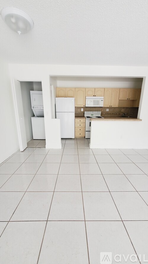 A kitchen with white appliances and cabinets.