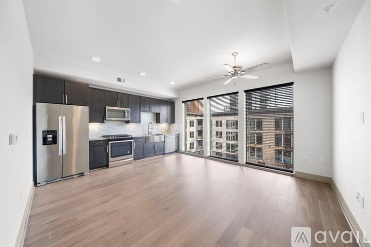 A spacious kitchen with stainless steel appliances and wooden flooring.