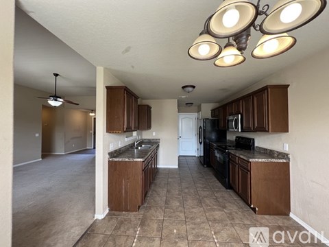 A kitchen with brown cabinets and a tile floor.