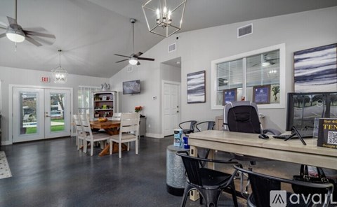A room with a table, chairs, and a fan.