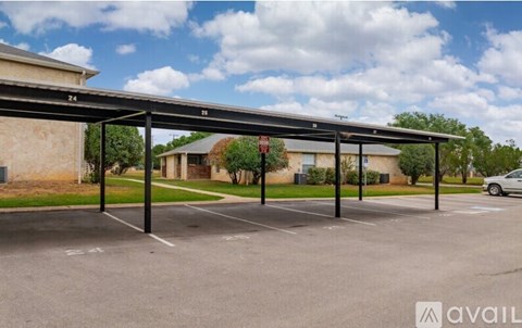 A parking lot with a clear sky and a building in the background.