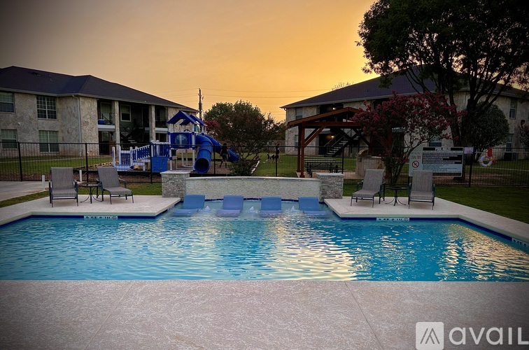 A pool with a slide and a building in the background.