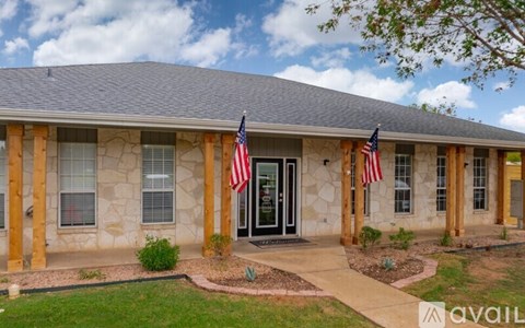 A house with a stone facade and two American flags on either side of the entrance.