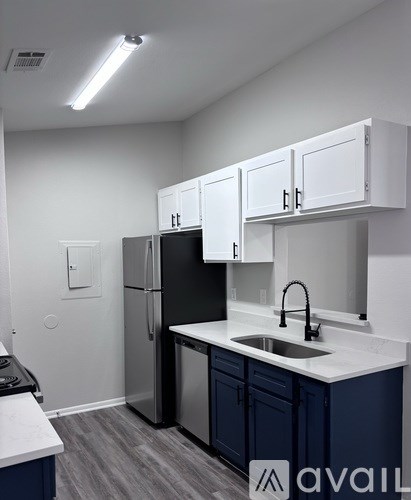 A kitchen with black appliances and white cabinets.