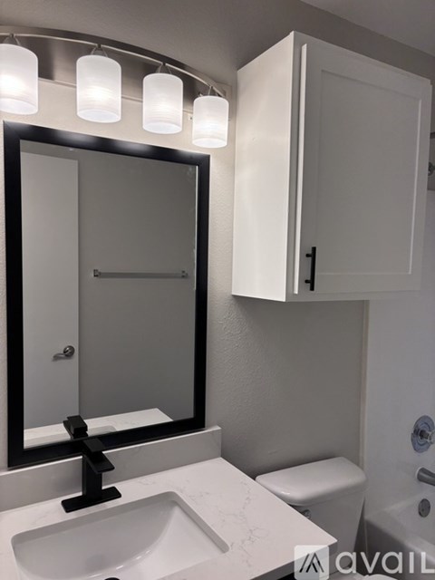 A bathroom with a sink, mirror, and toilet.