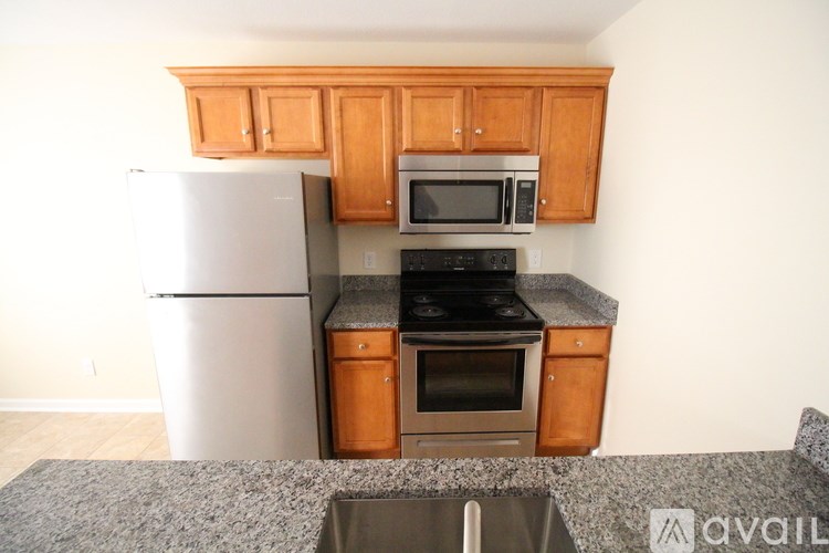 A kitchen with wooden cabinets and a granite countertop.
