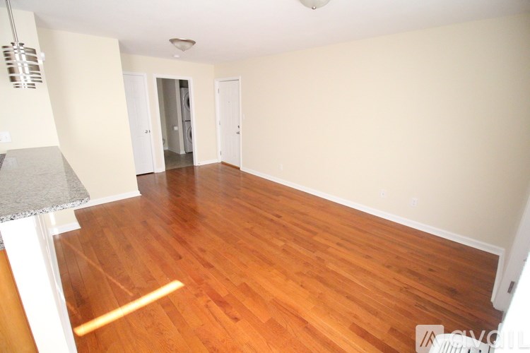 A room with wooden flooring and white walls.
