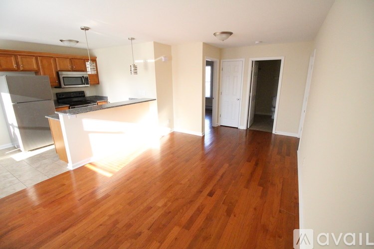 A kitchen with wooden floors and a refrigerator.