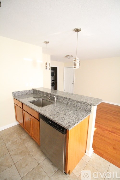 A kitchen with a granite countertop and wooden cabinets.