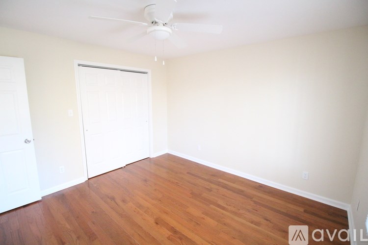 A room with a wooden floor and a ceiling fan.