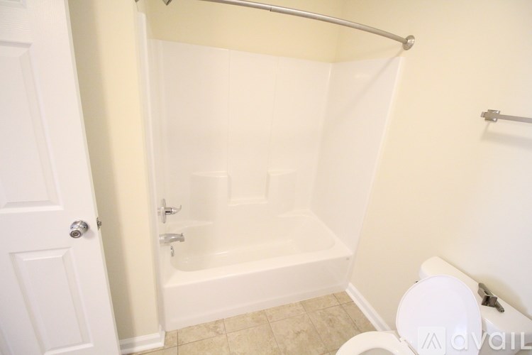 A white bathroom with a tub, toilet and sink.