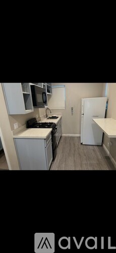 A kitchen with a white counter top and a black stove.
