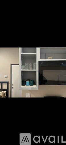 A bedroom with a bed, a chair, and a toilet visible through the open door.