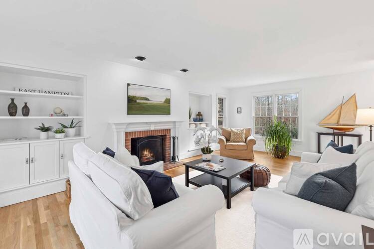A living room with a fireplace and a white couch.