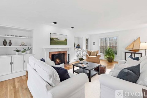 A living room with a fireplace and a white couch.