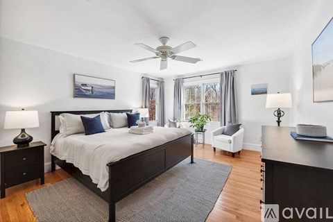 A bedroom with a large bed and a ceiling fan.