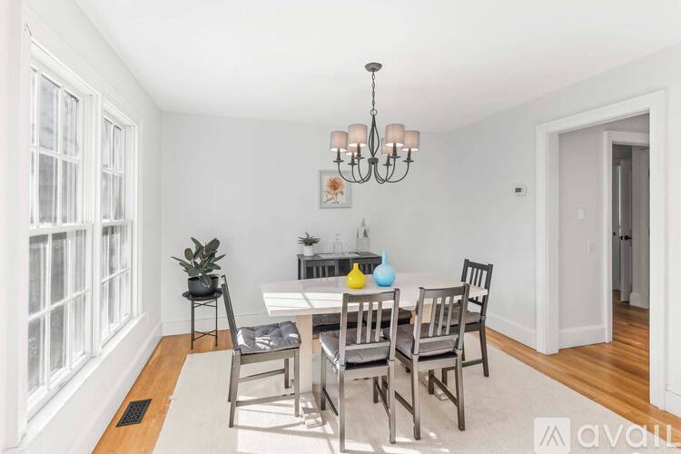A dining room with a white table and chairs.