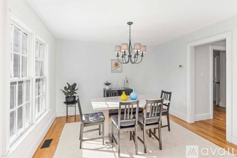A dining room with a white table and chairs.