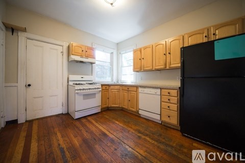A kitchen with wooden floors and white appliances.
