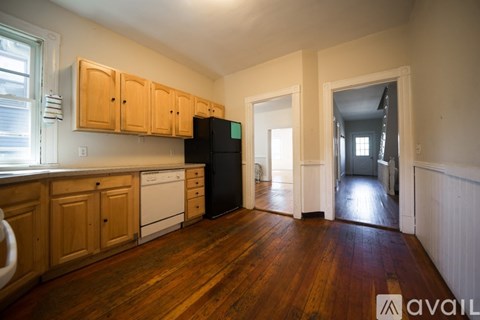 A kitchen with wooden floors and cabinets.