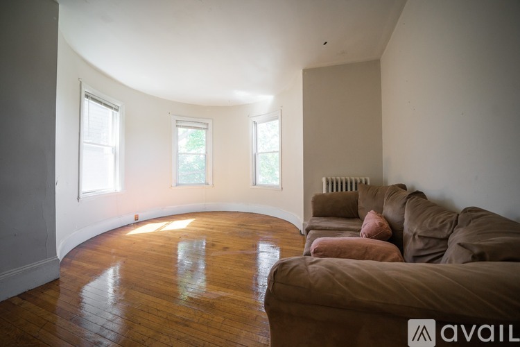 A living room with a brown couch and a wooden floor.