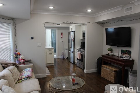 A living room with a couch, coffee table, and television.