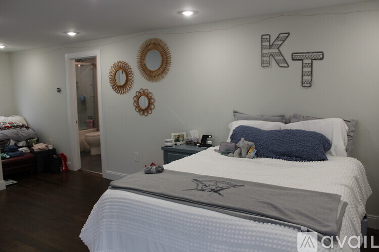 A bedroom with a large bed and a wall decoration that spells "KT".