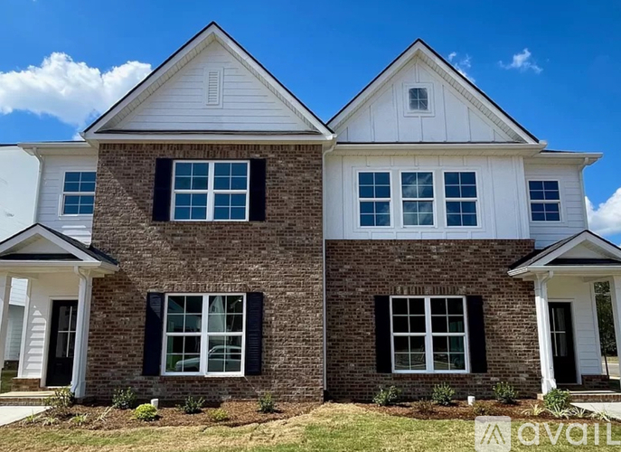 A two-story house with a brick facade and white trim.