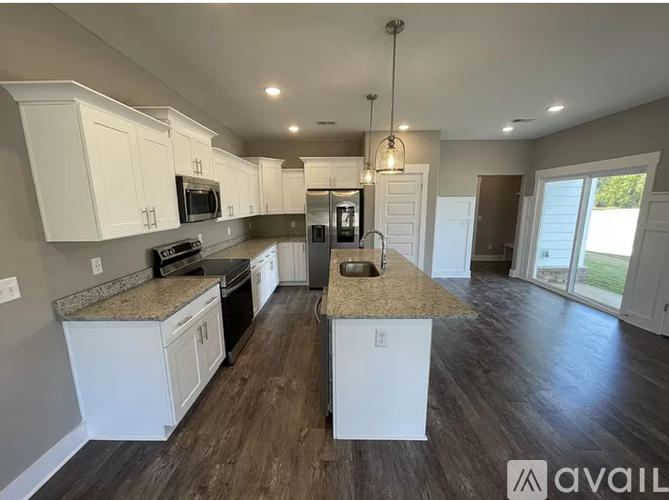 A kitchen with white cabinets and a granite countertop.