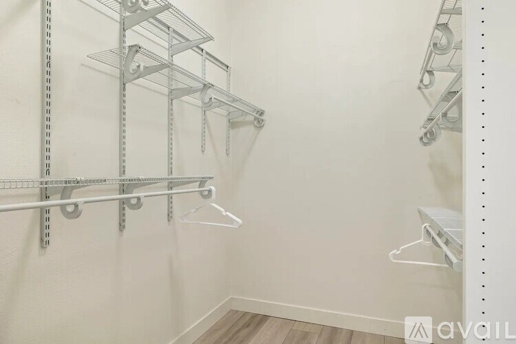 A white wall with a metal shelf attached to it.