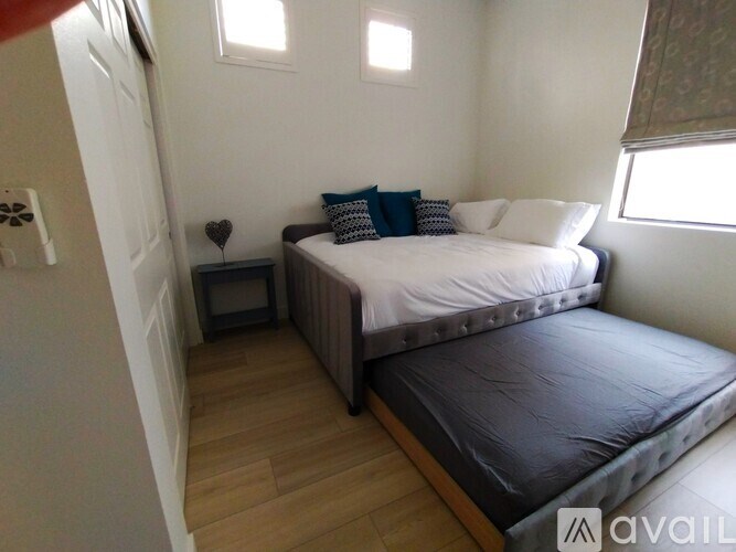 A bedroom with a bed, nightstand, and window.