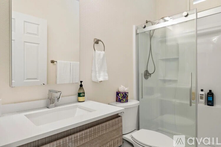 A bathroom with a sink, toilet, and shower.