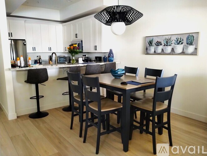A kitchen with a table and chairs in the foreground.