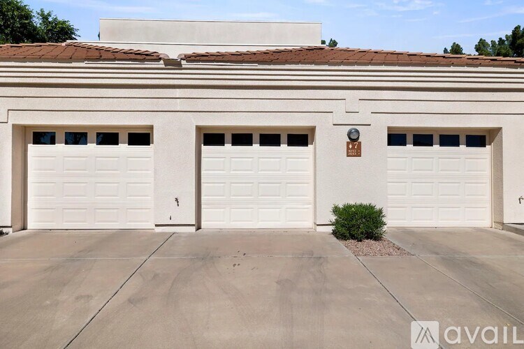 A two-car garage with a small bush in front of it.