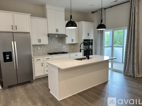 A kitchen with white cabinets and a central island.