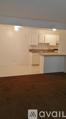A kitchen area with a refrigerator, sink, and countertop.