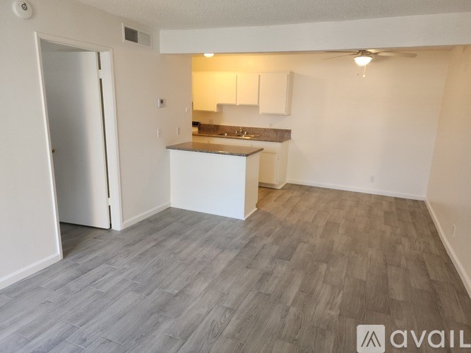 A kitchen area with a refrigerator, sink, and countertop.