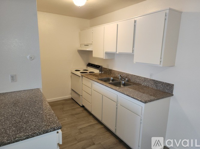 A kitchen with white cabinets and a granite countertop.