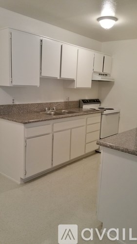 A kitchen with white cabinets and a granite countertop.