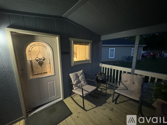 A patio with a door and two chairs.