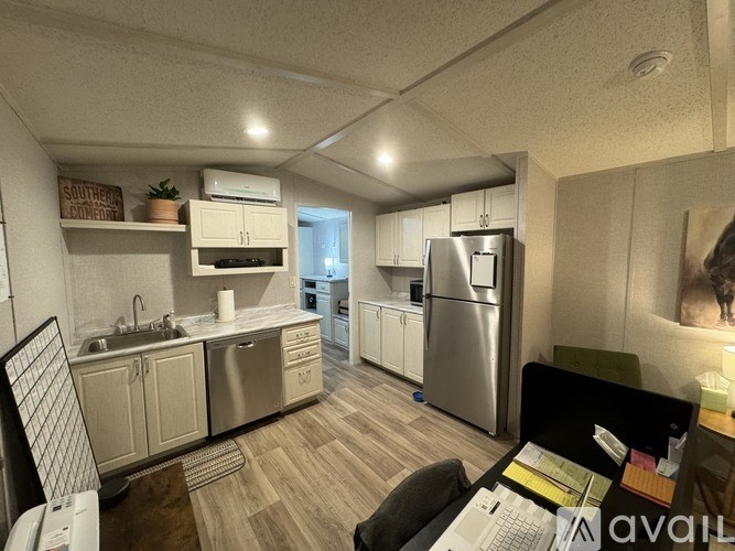 A kitchen with a refrigerator, sink, and cabinets.