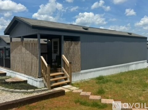 A house with a grey exterior and a wooden porch.