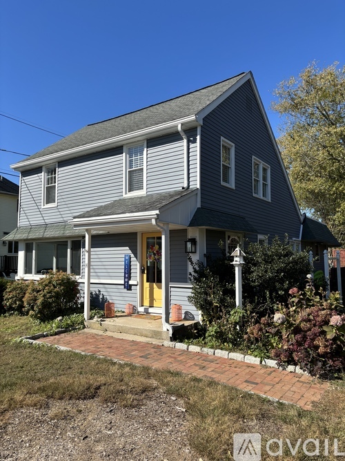 A house with a grey exterior and a yellow door.