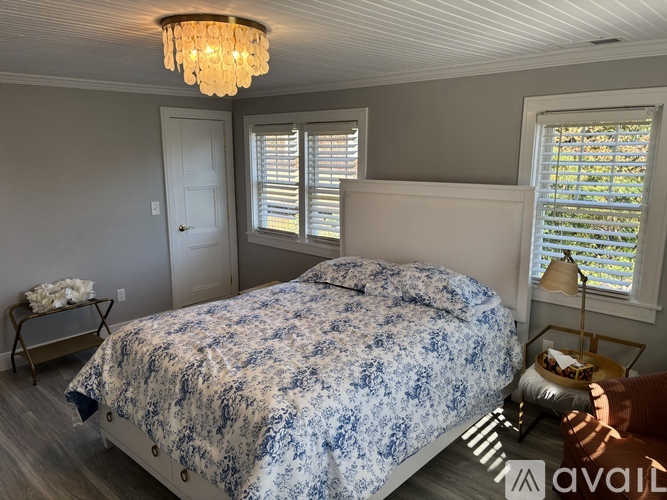 A bedroom with a bed covered in a blue and white patterned bedspread.