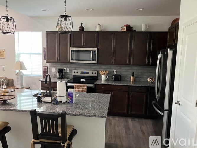 A kitchen with brown cabinets and a granite countertop.