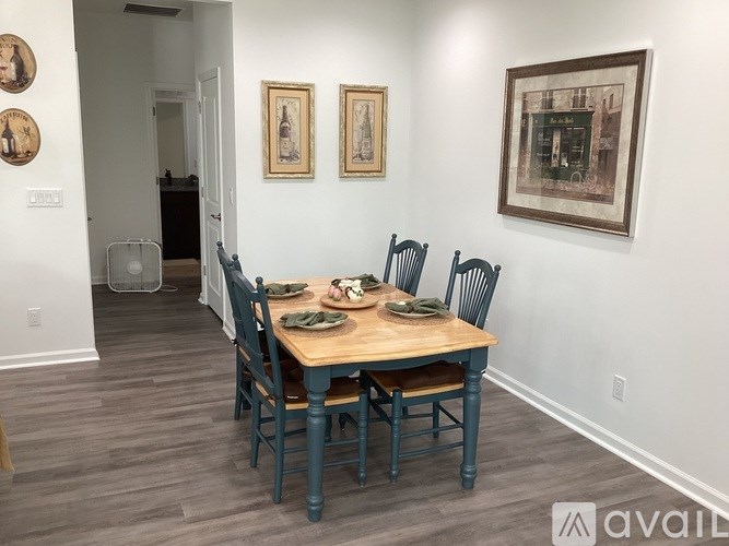 A dining room with a wooden table and chairs.